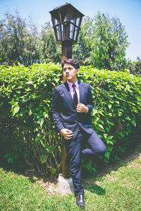 Handsome young man standing in park during sunny day