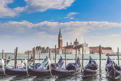 Boats moored in canal against sky