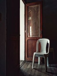 Empty chair on table by window in old house