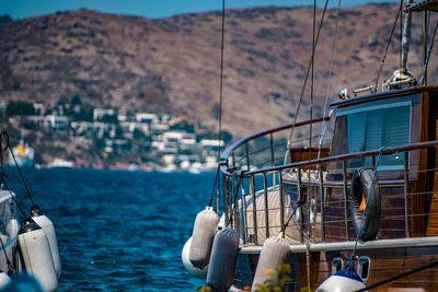 Yacht moored on sea against mountains