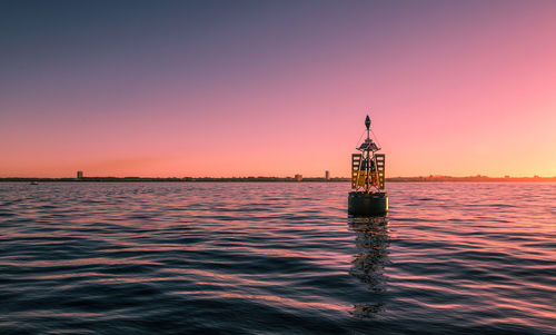 Scenic view of floating ocean border sign against sky during sunset