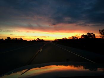 Road passing through landscape against cloudy sky