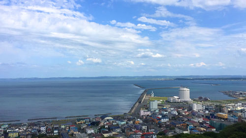 High angle view of buildings by sea against sky