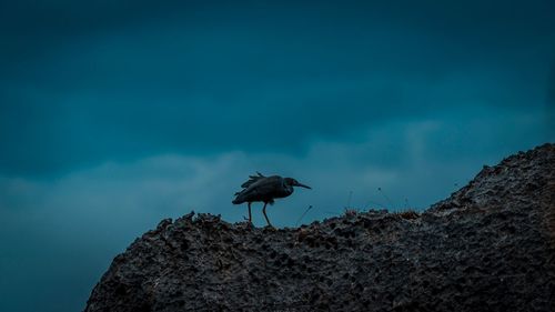 Low angle view of silhouette rock formation against sky