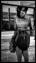 Portrait of young man looking through window