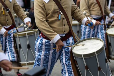 Midsection of men playing drums