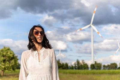 Young woman standing against sky