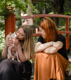 Happy ginger hair woman with friend in well-groomed park or garden. support and healthy way of life