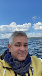 Portrait of man smiling in sea against sky