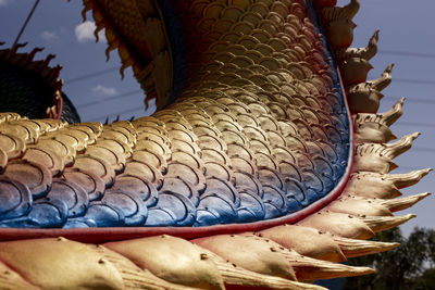 Close-up of fish statue on roof against building