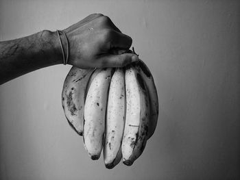 Close-up of hand holding ice cream over white background