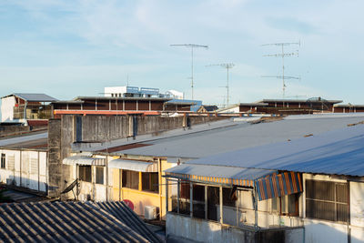 Houses by buildings against sky