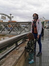 People standing on bridge against sky