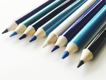 High angle view of colored pencils against white background