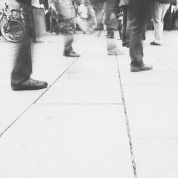 Low section of people standing on tiled floor