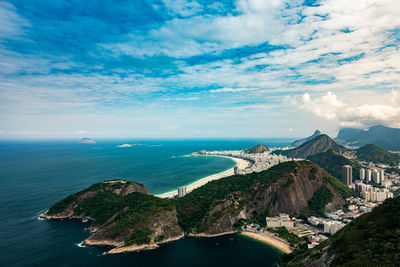 Aerial view of sea and mountains against cloudy sky