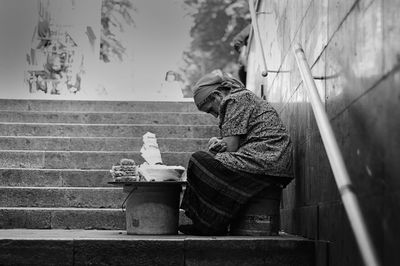 Rear view of woman sitting on staircase