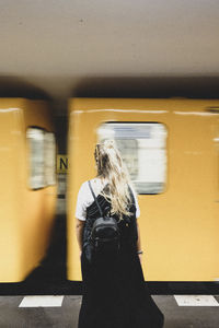 Rear view of woman standing at subway station