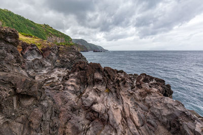 Rock formations by sea against sky