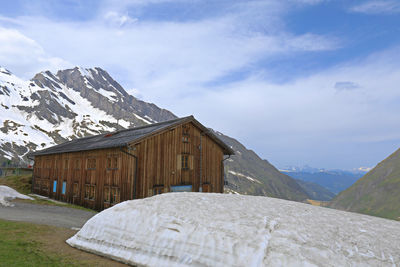 Built structure on snowcapped mountain against sky