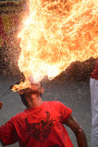 Man blowing fire at night