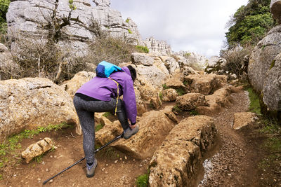 Woman tying shoelace on rock