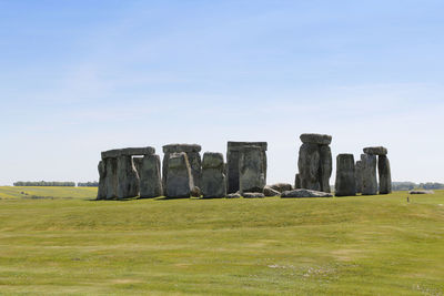 View of stonehenge with green meadow and blue sky on a sunny day in spring, united kingdom