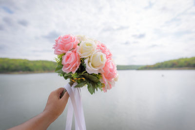 Close-up of hand holding rose bouquet