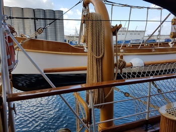 Sailboat hanging over sea by ship