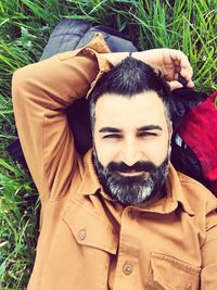 Portrait of young man lying on grass