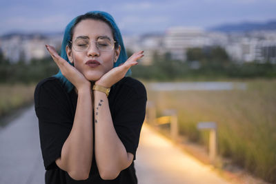 Close-up of beautiful young woman gesturing while standing outdoors