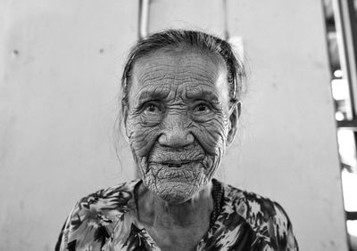 Close-up of wrinkled senior woman looking away at home