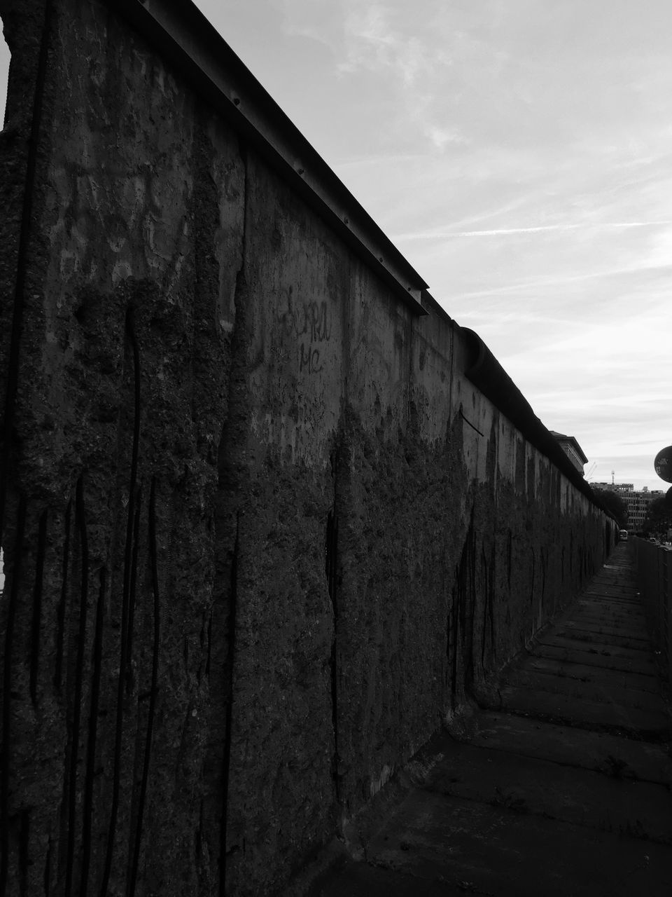 LOW ANGLE VIEW OF WEATHERED WALL BY BUILDING