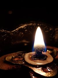 Close-up of illuminated tea light candle against black background