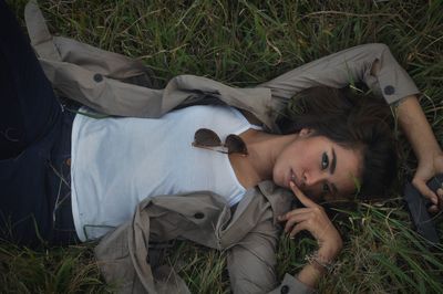 Portrait of young woman lying on land