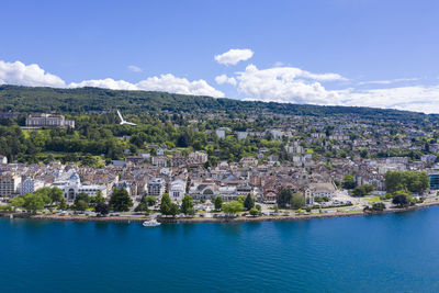 High angle view of townscape by sea against sky