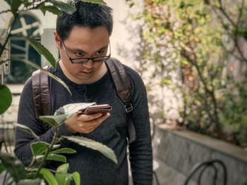 Young man using mobile phone outdoors