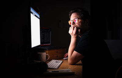 Man using computer at home at night