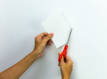 Midsection of person holding paper against white background
