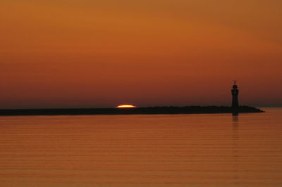 Scenic view of sea against orange sky