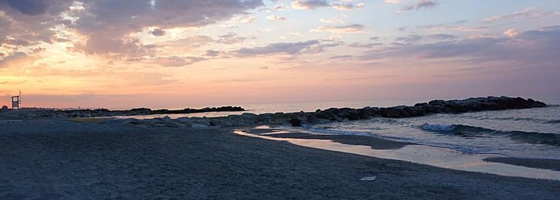 Scenic view of beach against sky during sunset