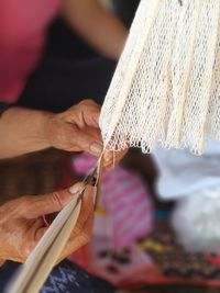 Cropped hands knitting thread in factory