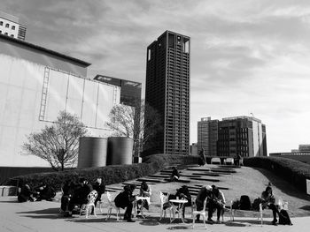 People at modern office building against sky