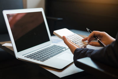 Low section of person using laptop on table