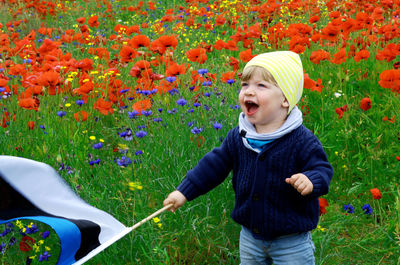 Happy girl playing with flowers in yard