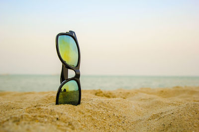 Close-up of sunglasses on beach