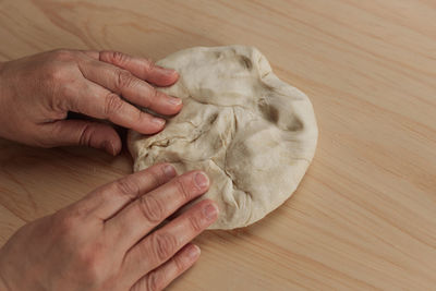 High angle view of person holding hands on table