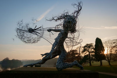 Dead tree against sky during sunset