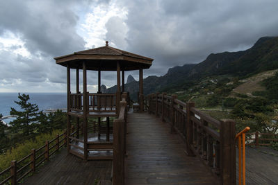 Lifeguard hut by mountains against sky