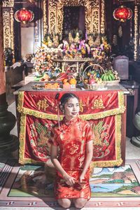 Full length of woman sitting at temple